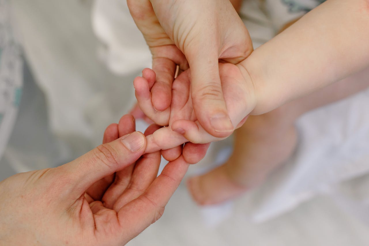 Close-up of an adult giving a gentle massage to a baby